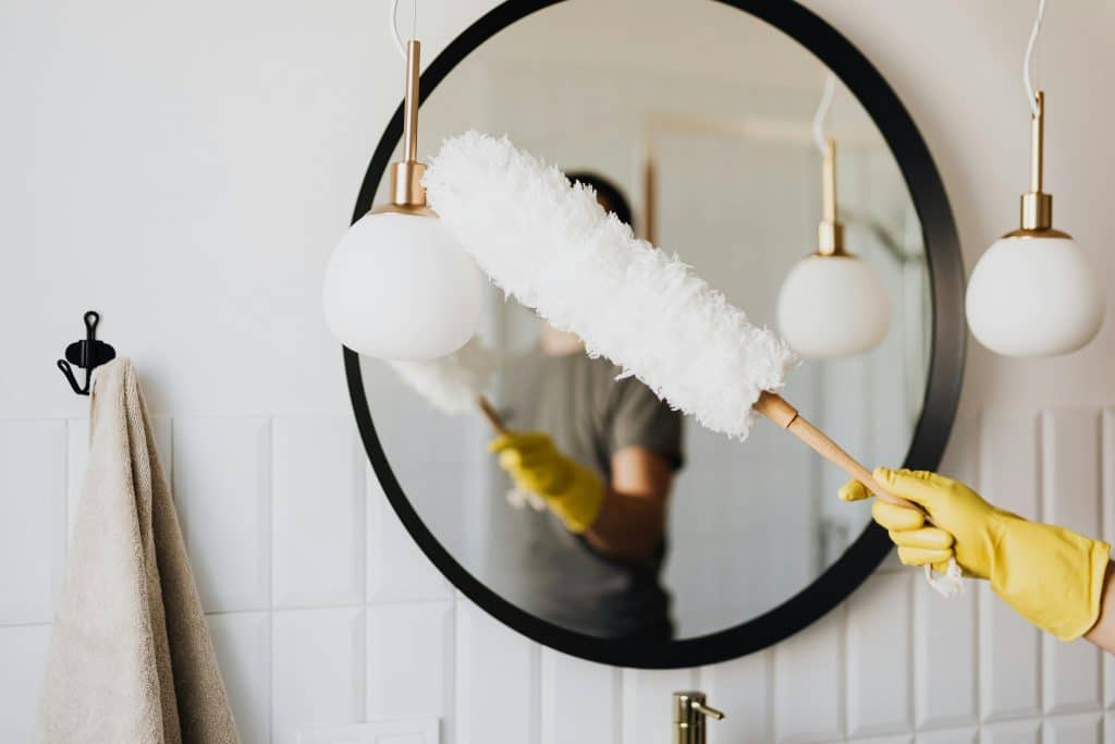 Professional house cleaner from Merit Maids sanitizing a bright modern kitchen in Arvada, CO, showcasing recurring cleaning services in action.