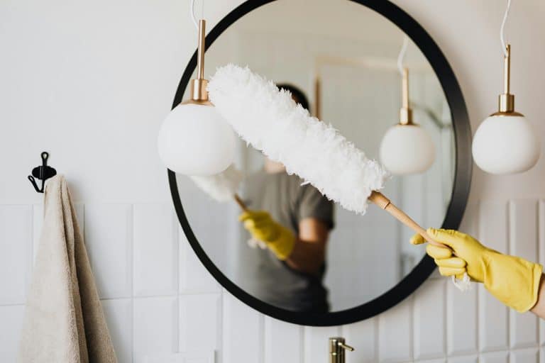 Professional house cleaner from Merit Maids sanitizing a bright modern kitchen in Arvada, CO, showcasing recurring cleaning services in action.
